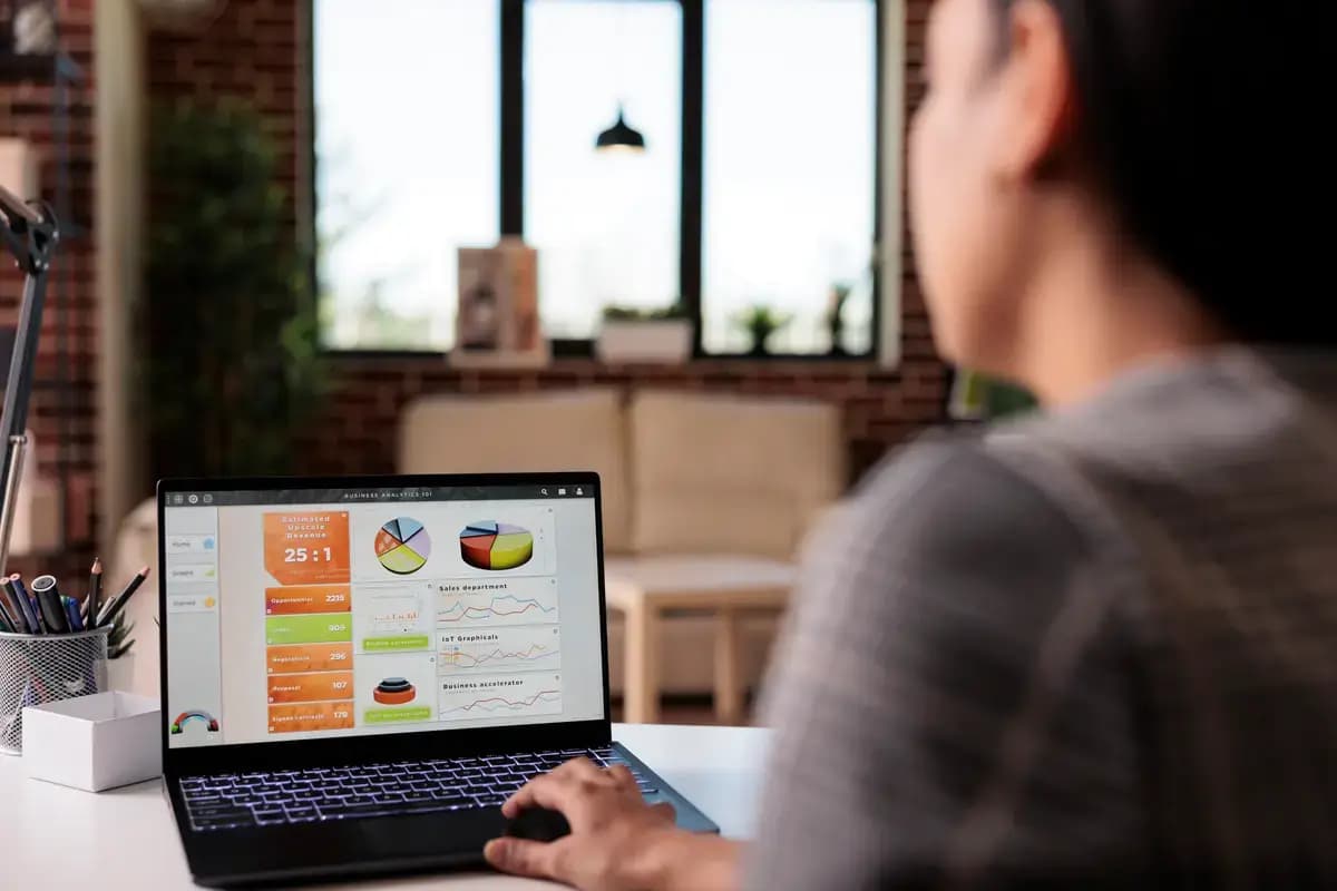 A person reviewing a dashboard of charts and reports on a laptop